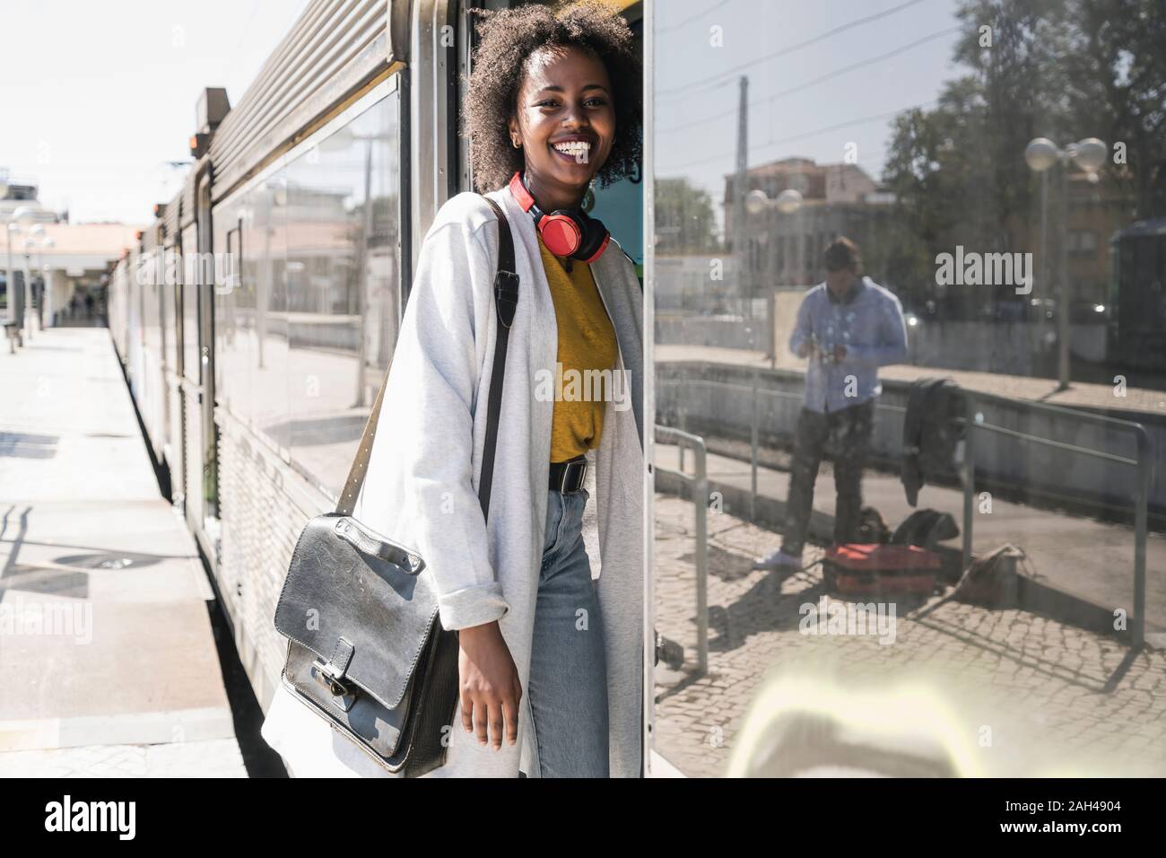 Happy young woman entering a train Stock Photo