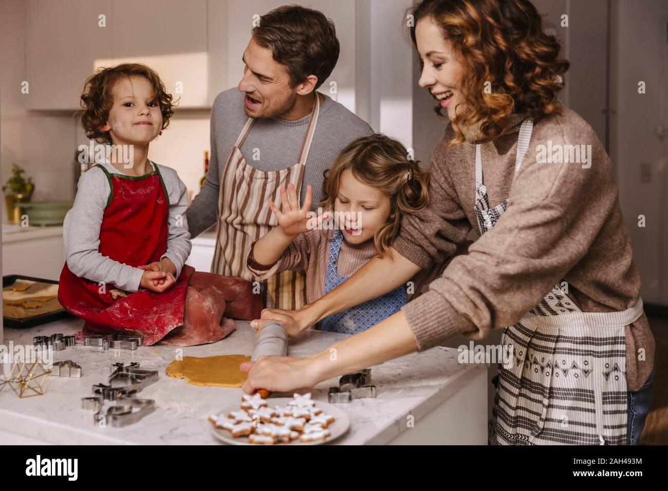 Family preparing Christmas cookies in kitchen Stock Photo