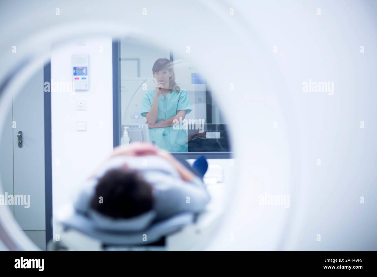 Patient in hospital during CT examination, female radiologist Stock Photo
