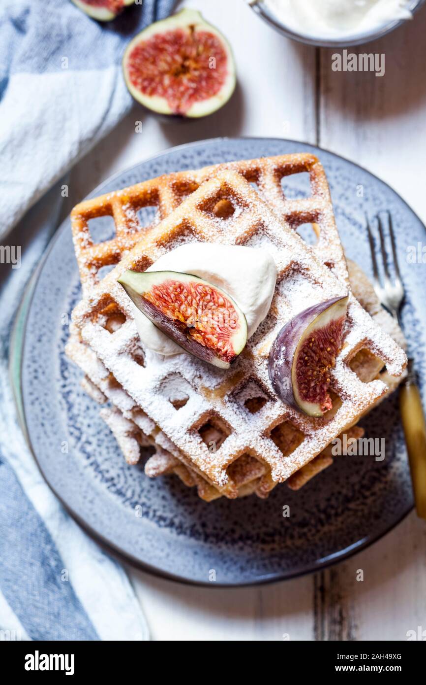 Plate of thick Belgian waffles with whipped cream, powdered sugar and figs Stock Photo