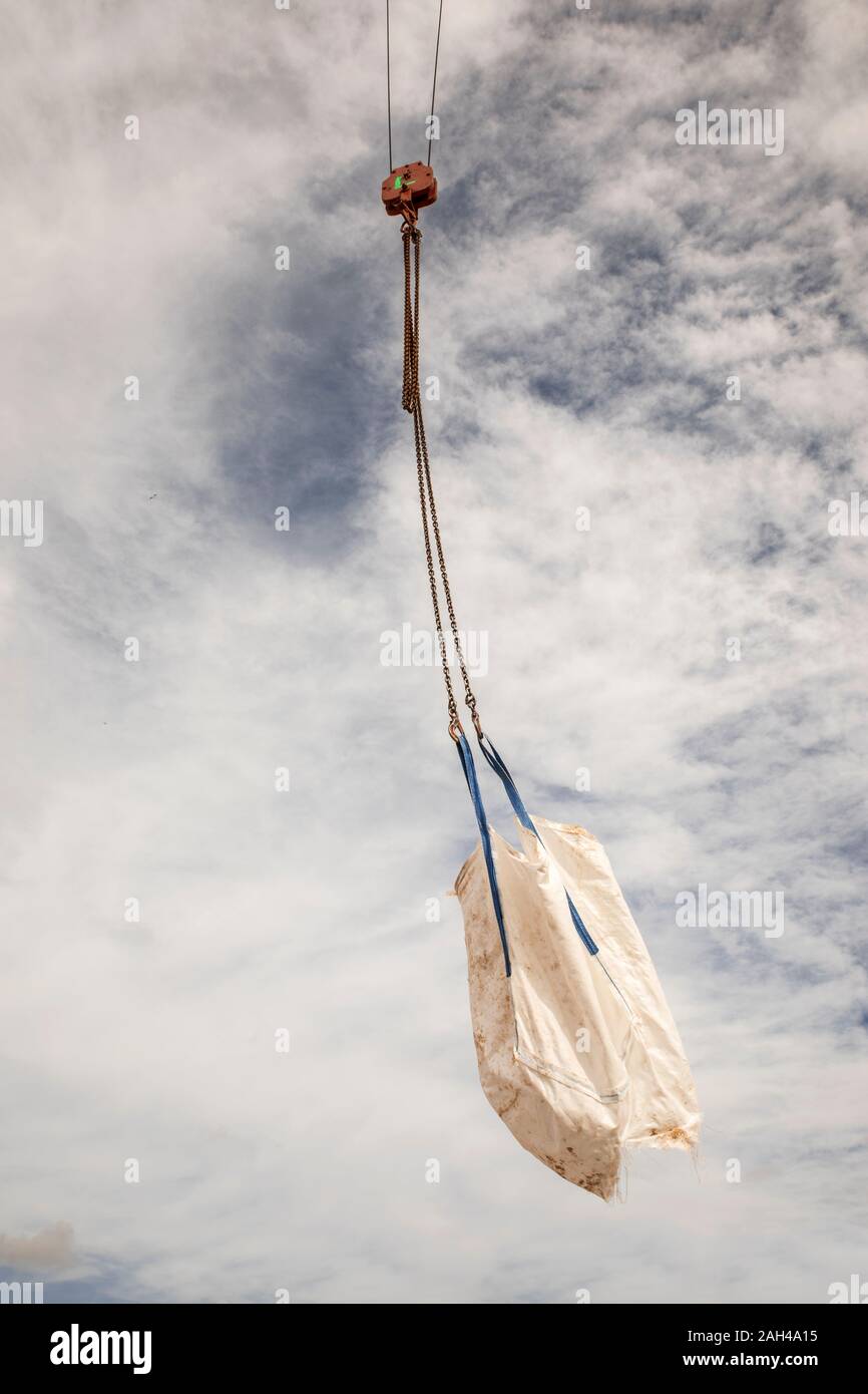 Sack hanging on the chain of a crane Stock Photo
