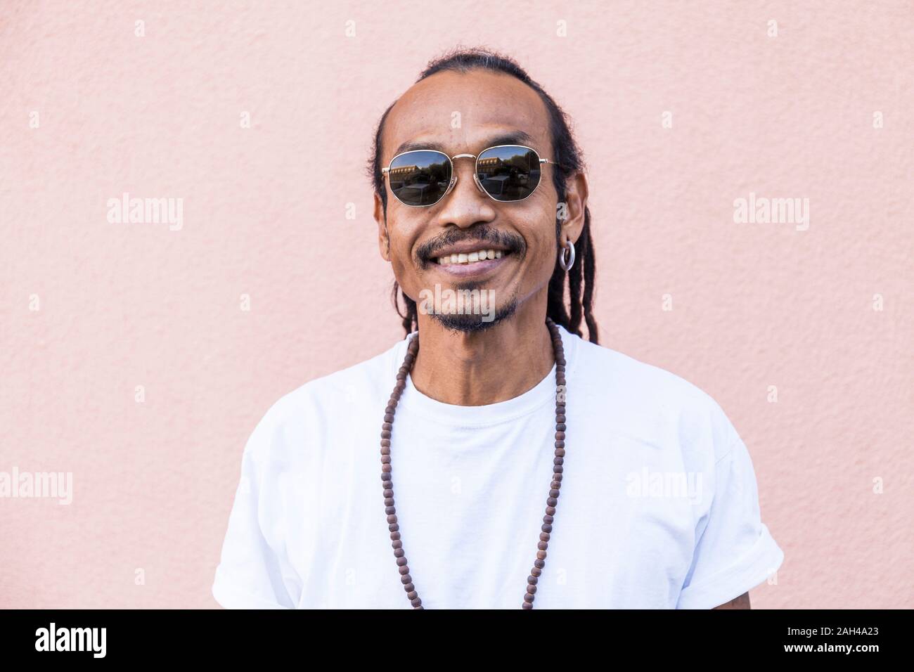 Portrait of smiling mature man with dreadlocks and sunglasses Stock Photo