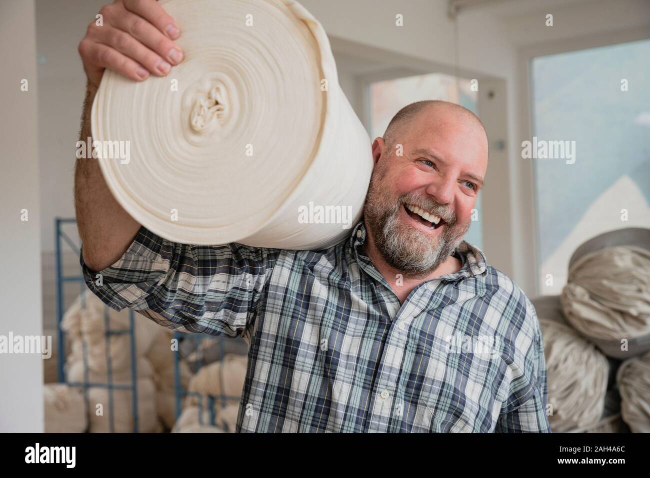 Worker with cotton fabric in a circular knitting mill Stock Photo