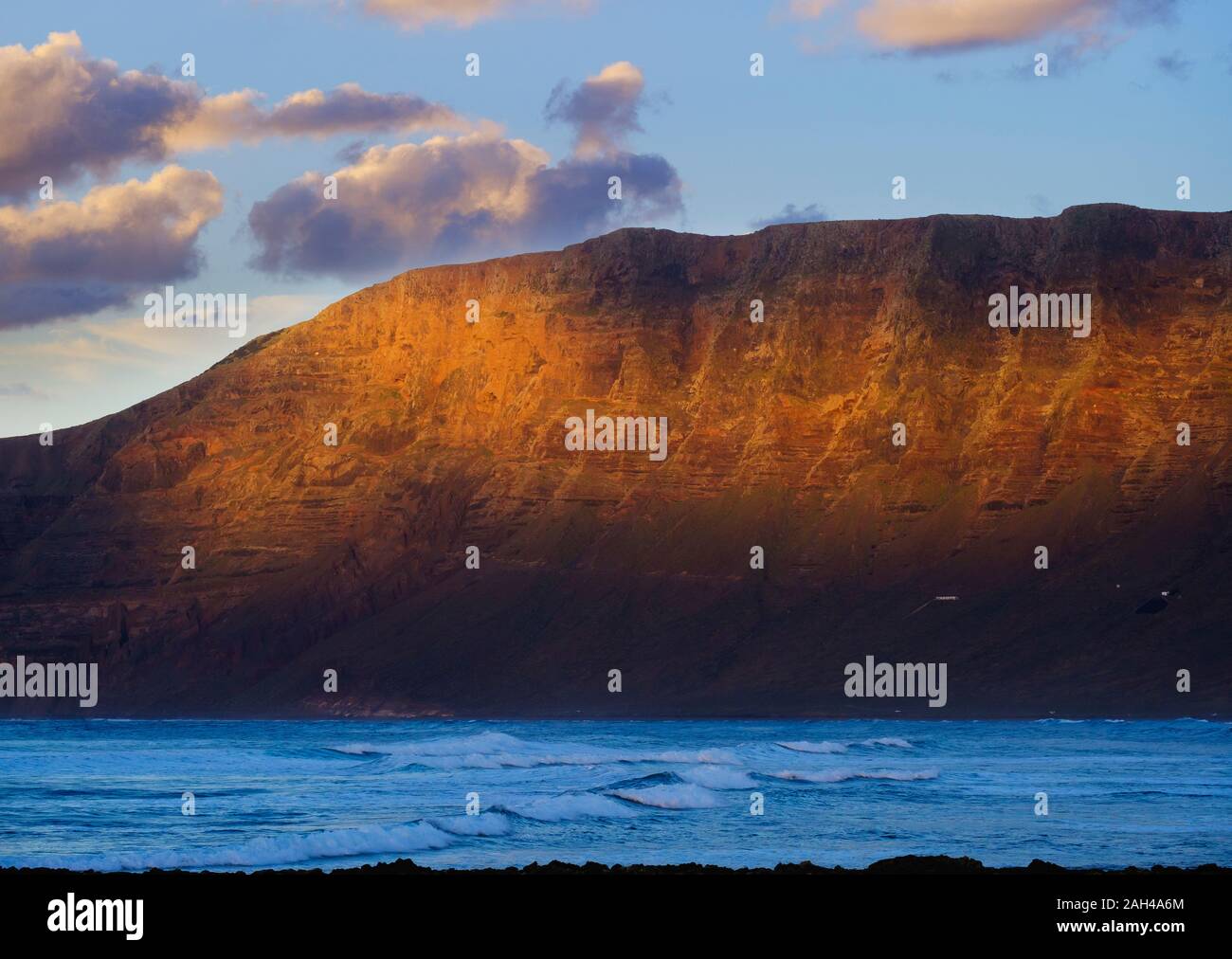 Spain, Canary Islands, Caleta de Famara, Risco de Famara at dusk Stock Photo