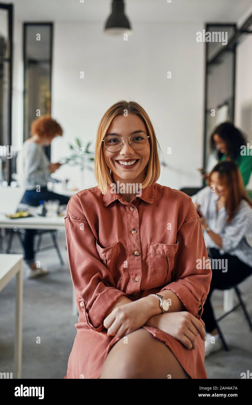 Portrait of a confident businesswoman in office with colleagues in background Stock Photo