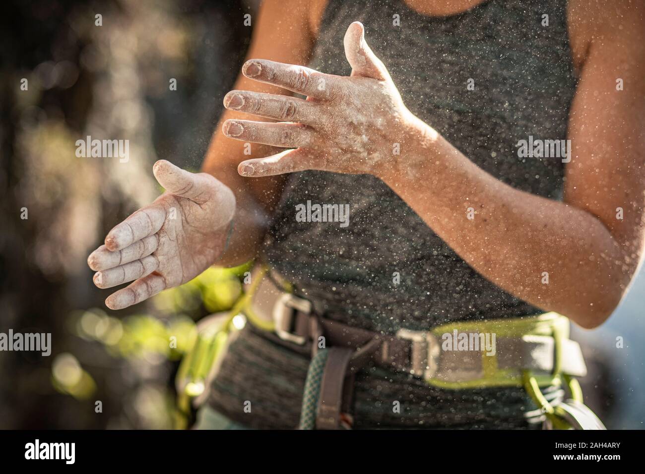 Woman preparing to climb, using chalk powder Stock Photo Alamy