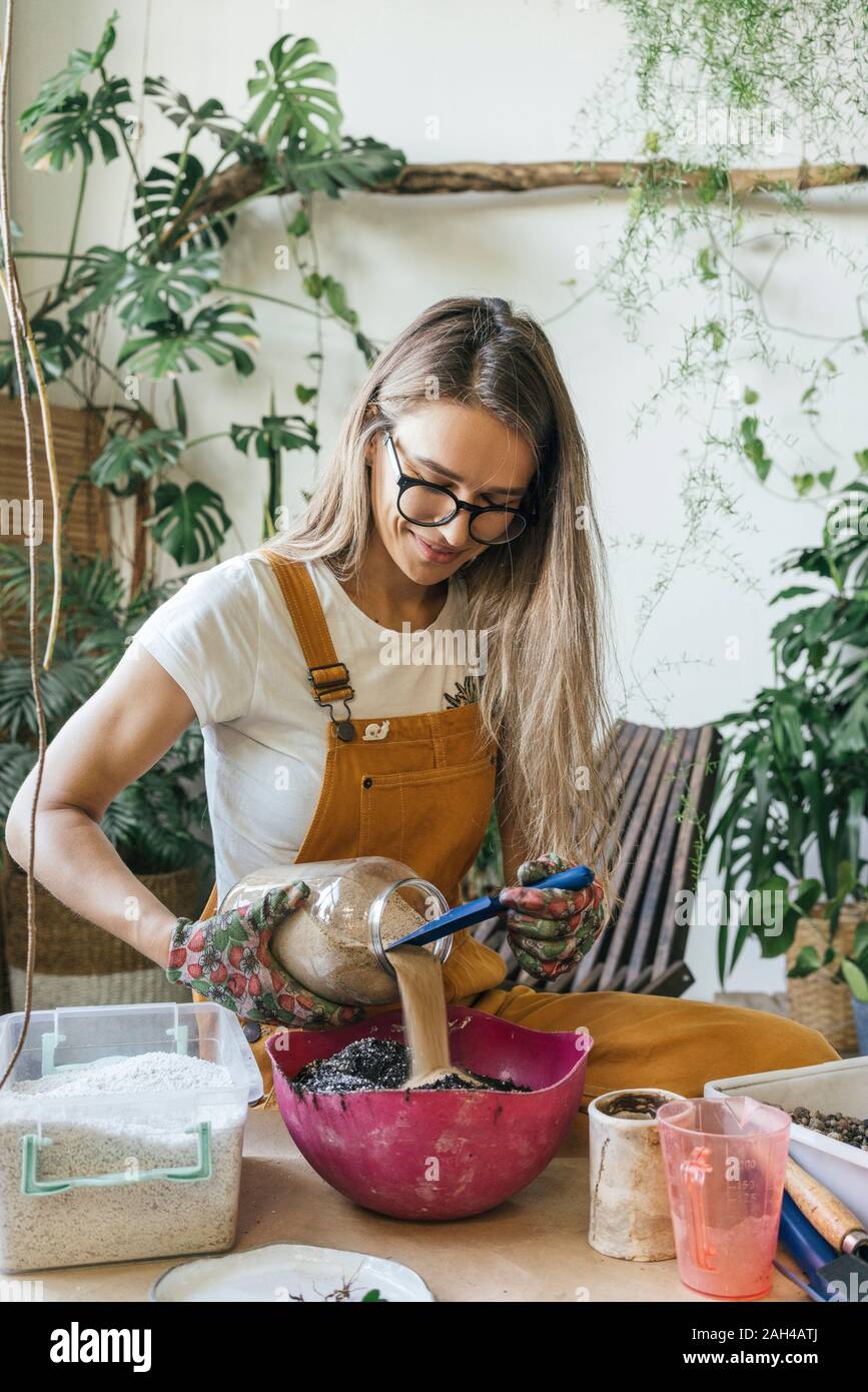 Young woman working at table in a small gardening shop Stock Photo