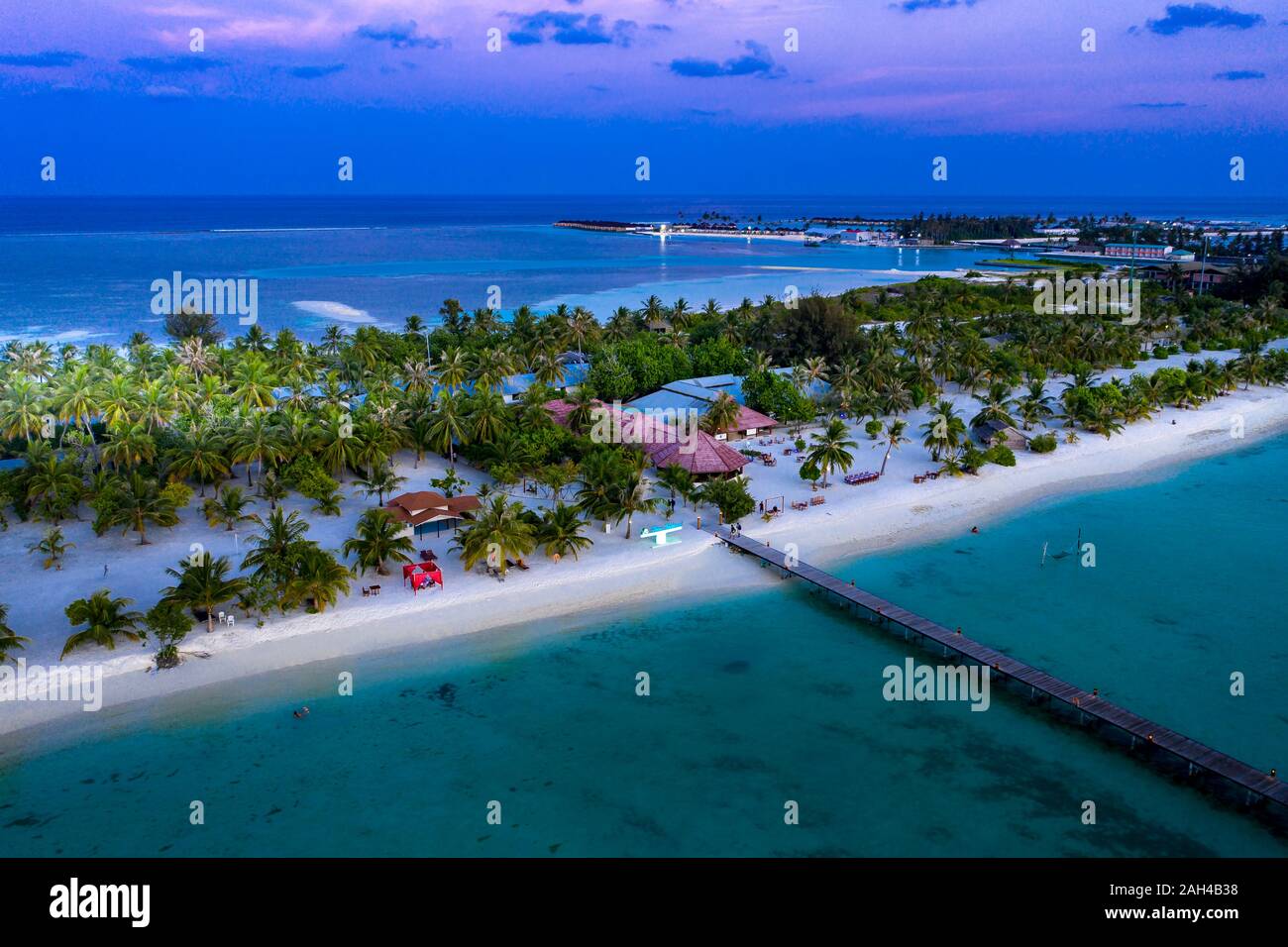 Maldives, Bodufinolhu, Aerial view of coastal tourist resort on South Male Atoll at dusk Stock Photo
