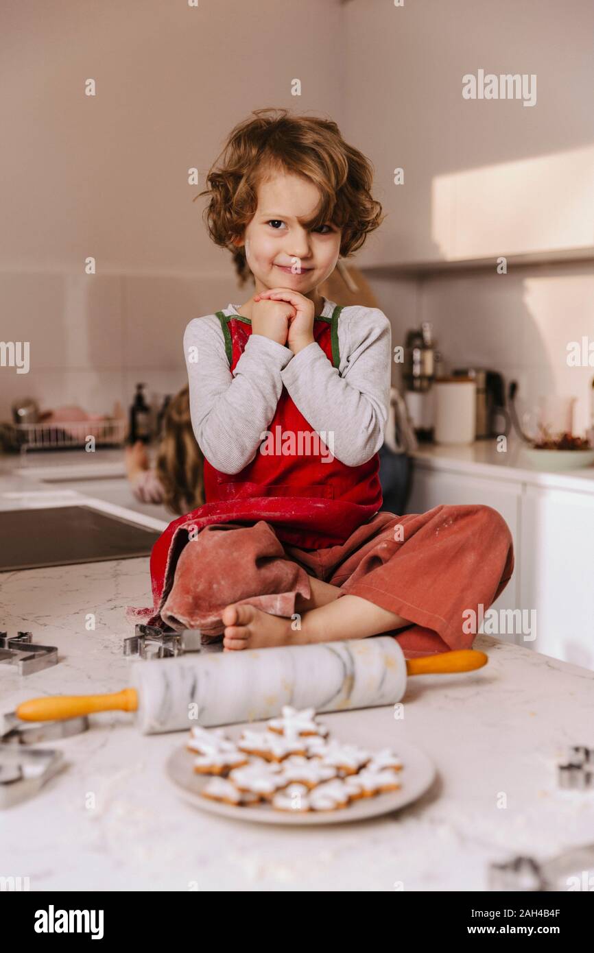 Portrait of smiling girl with Christmas cookies in kitchen Stock Photo