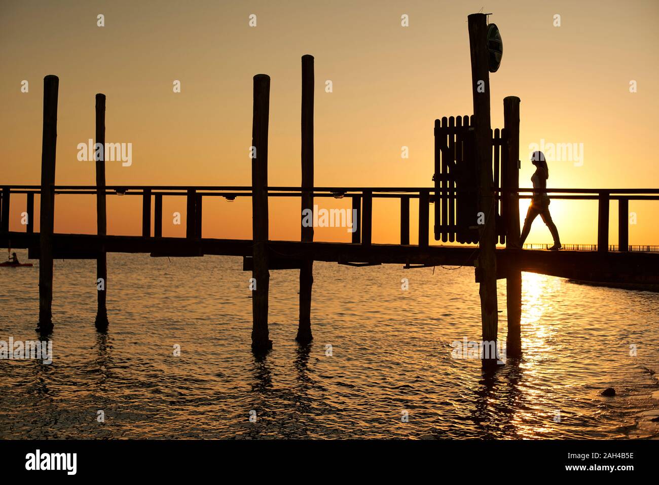 Silhouette of a woman walking on a bridge at sunset, Swakopmund ...