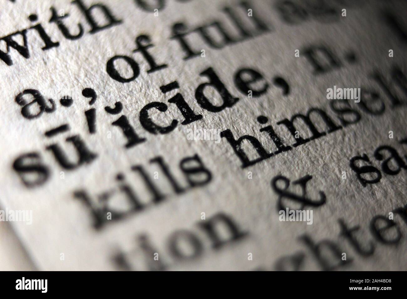 Word 'suicide' printed on book page, close-up Stock Photo