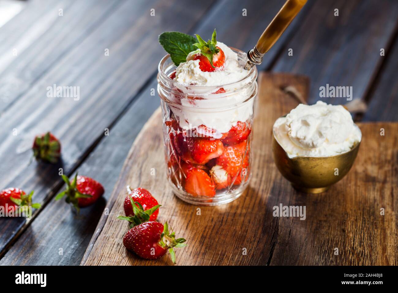 Jar of fresh strawberries with whipped cream Stock Photo