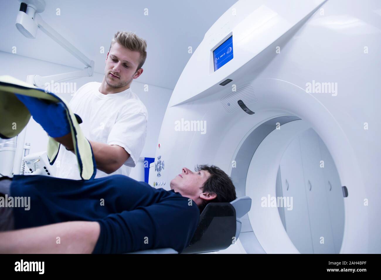 Patient in hospital during CT examination and radiologist Stock Photo