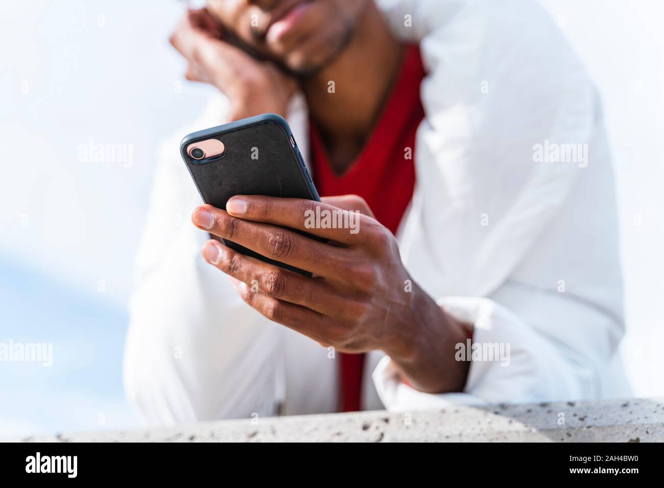 Close-up of young man using smartphone outdoors Stock Photo