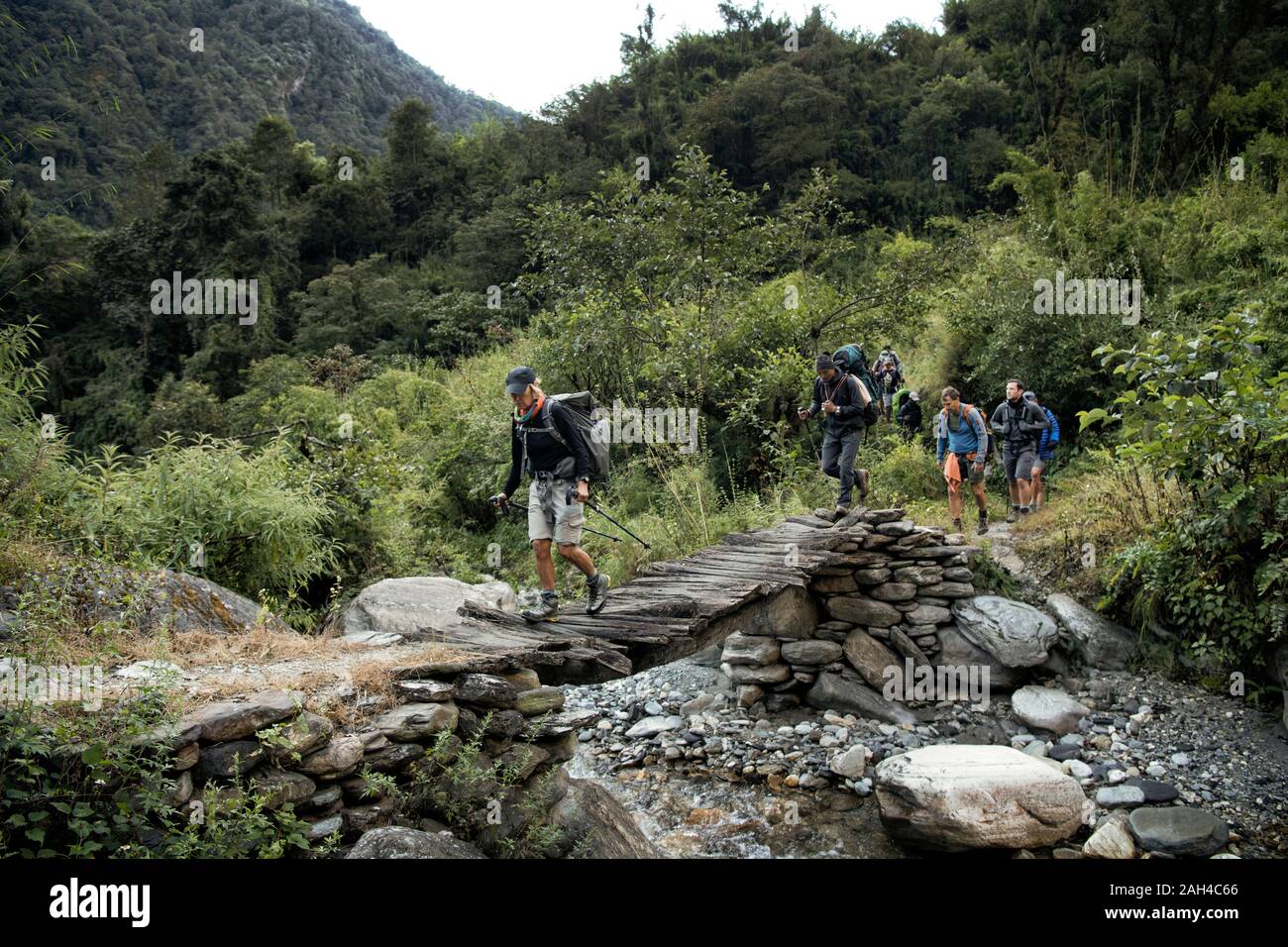 Trekking group crossing river at Myagdi Khola Gorge, Dhaulagiri Circuit Trek, Himalaya, Nepal Stock Photo