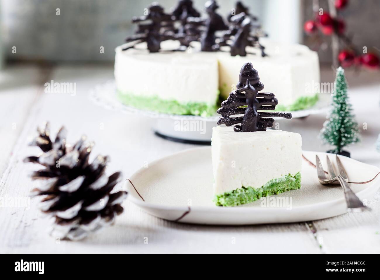 Piece of no-bake cheesecake, decorated with chocolate Christmas trees on plate Stock Photo