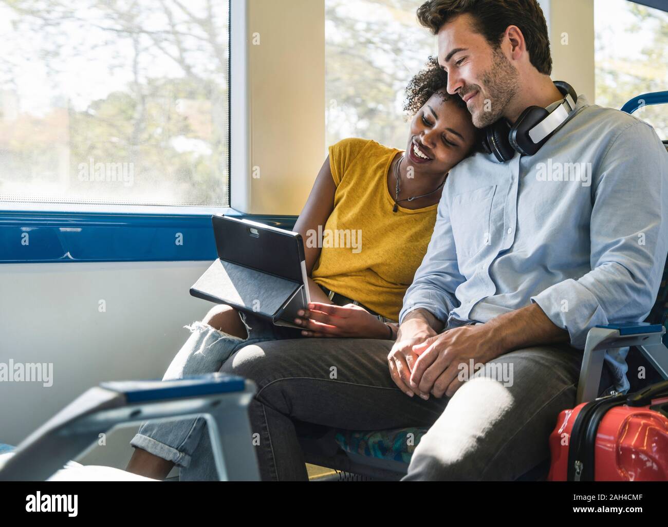 Young couple with tablet relaxing in a train Stock Photo