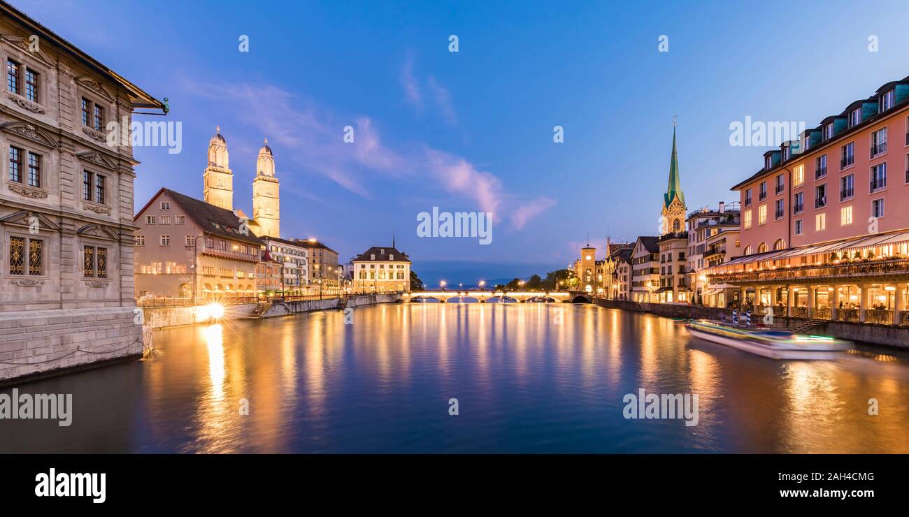Switzerland, Canton of Zurich, Zurich, River Limmat between illuminated old town waterfront buildings at dusk Stock Photo