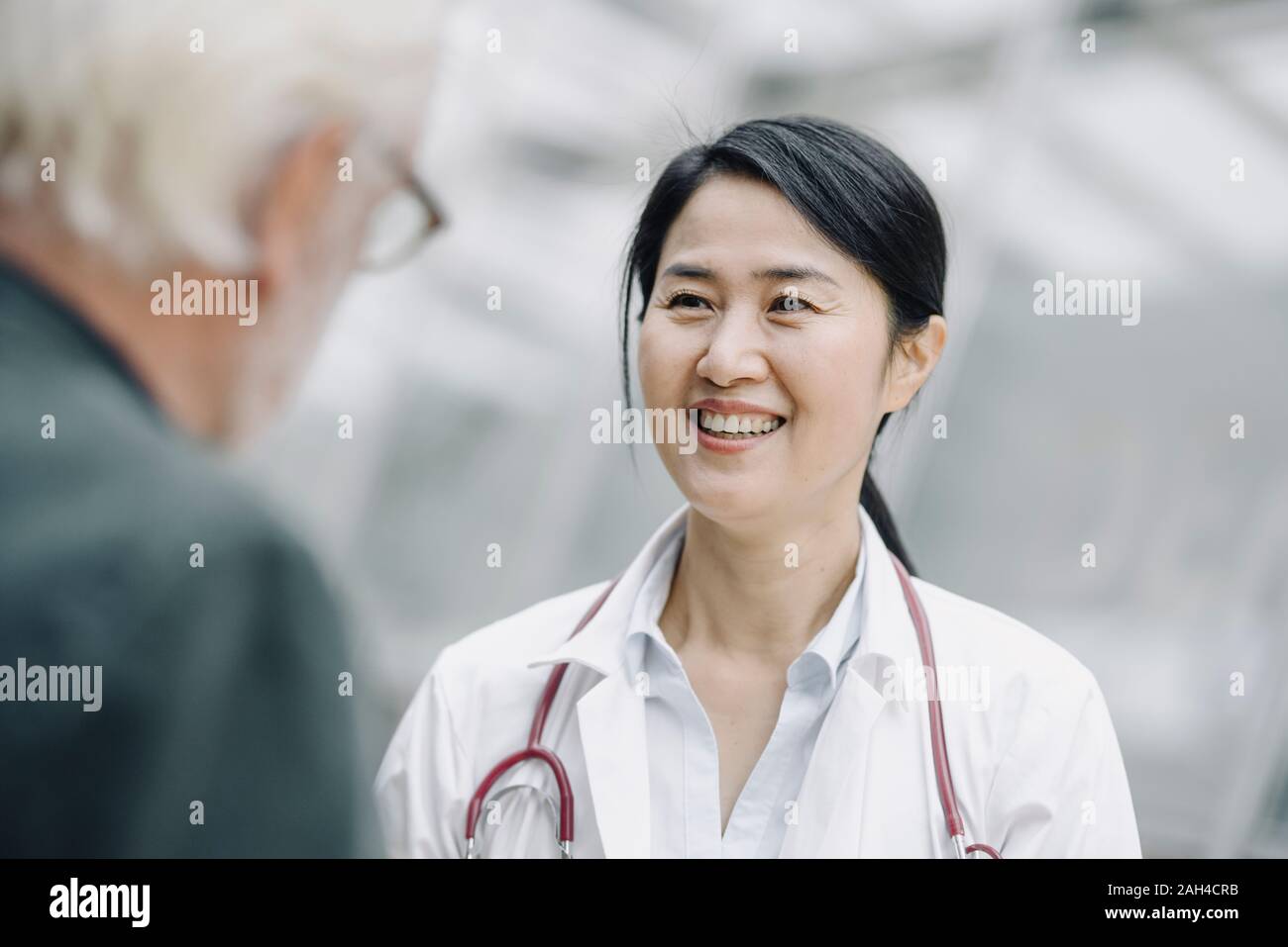 Smiling female doctor talking to senior man Stock Photo