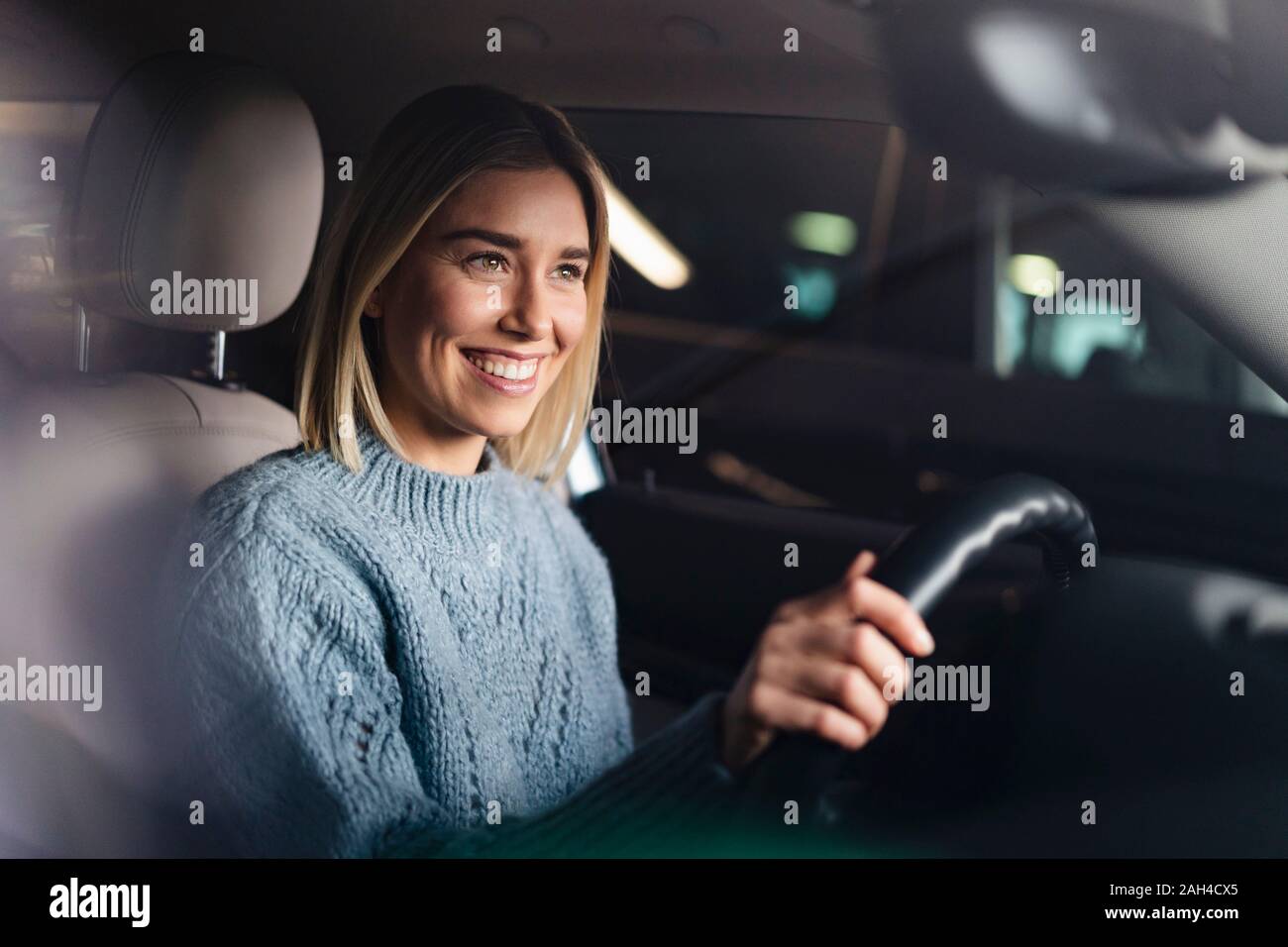 Portrait of happy young woman driving a car Stock Photo