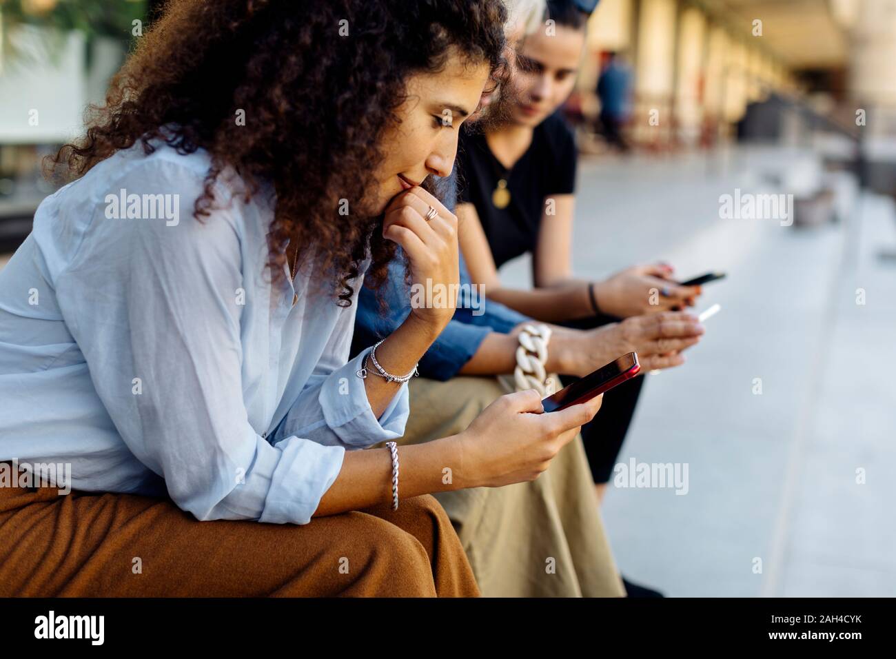 Three women sitting in row hi-res stock photography and images - Alamy