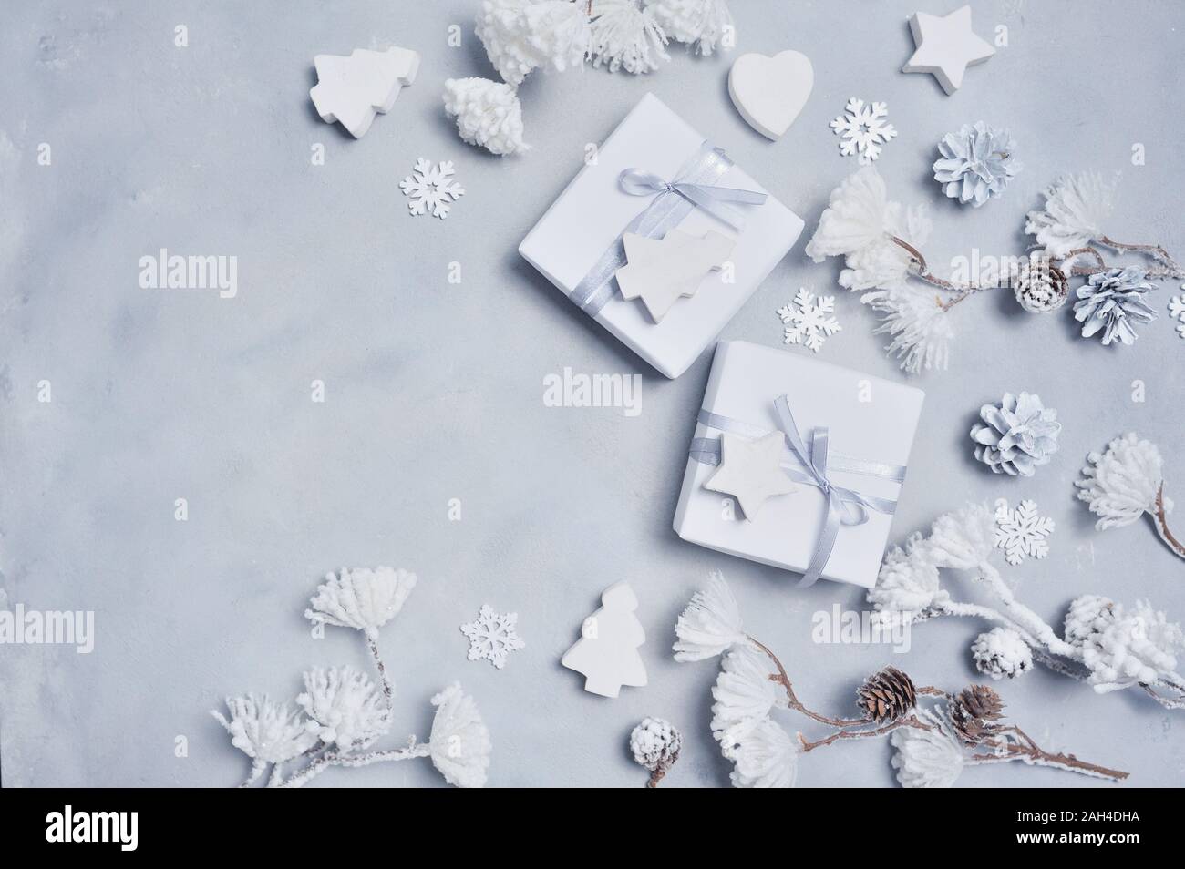Border Design a Christmas greeting card with Xmas gift box, cones, snowflakes with place for your text. Decorations on a white concrete background Stock Photo