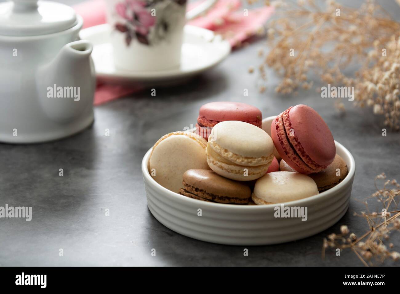 French macaron cakes in a plate close up. Cream, brown, pink, macarons