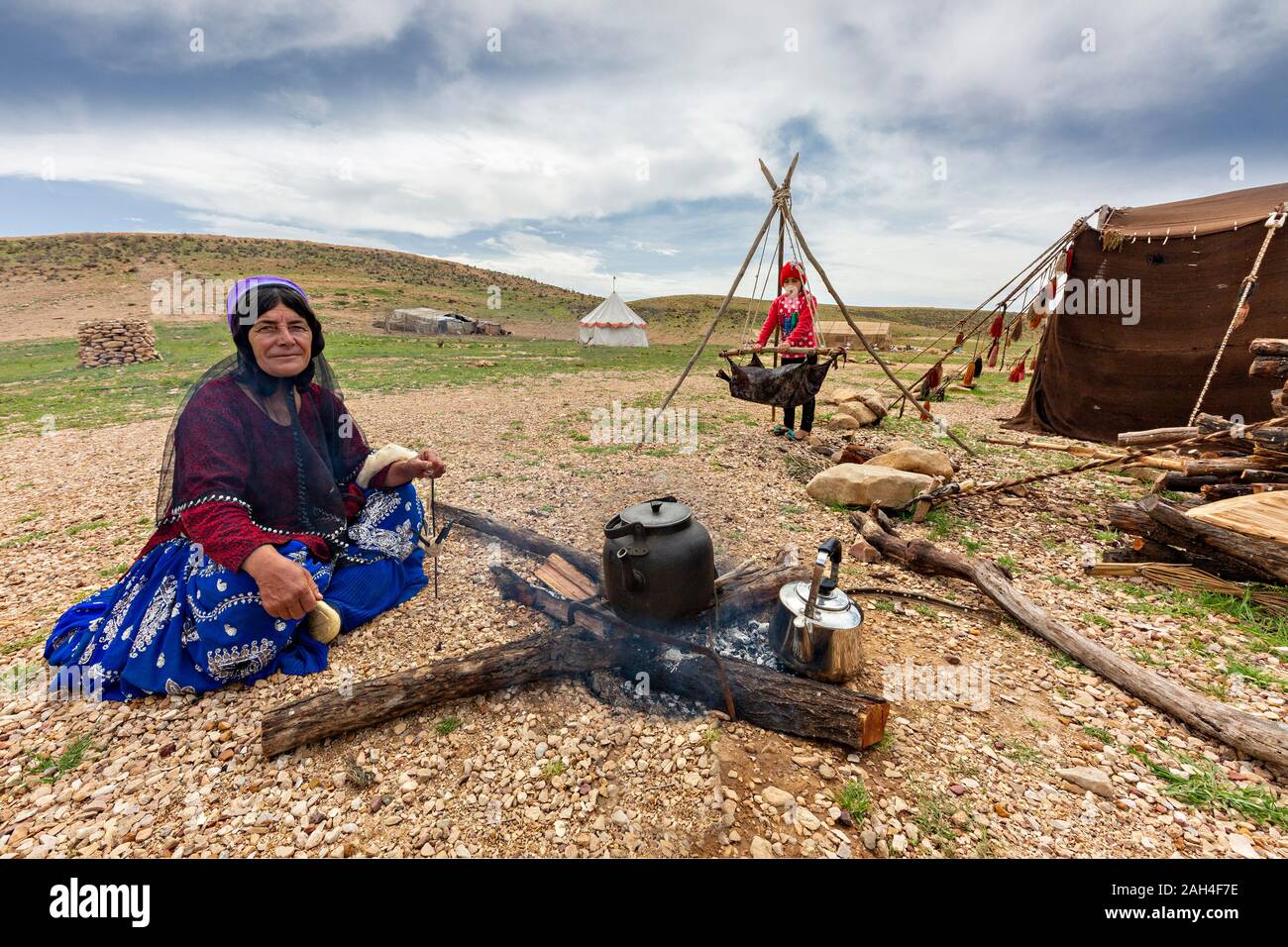Nomadic woman from Qashqai nomads spins wool and makes tea, near Shiraz, Iran. Stock Photo