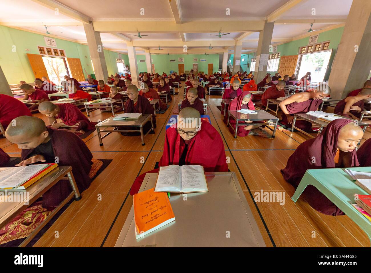Monks reading and studying in the classroom of the monastery in Mandalay, Myanmar Stock Photo