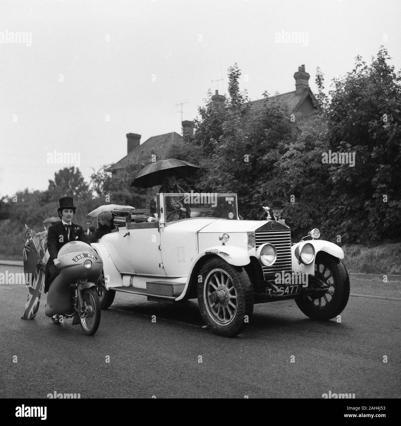 1967, historical, parade, english village, motorbike and a vintage rolls-royce motor car on a road, Buckinghamshire, England. Stock Photo