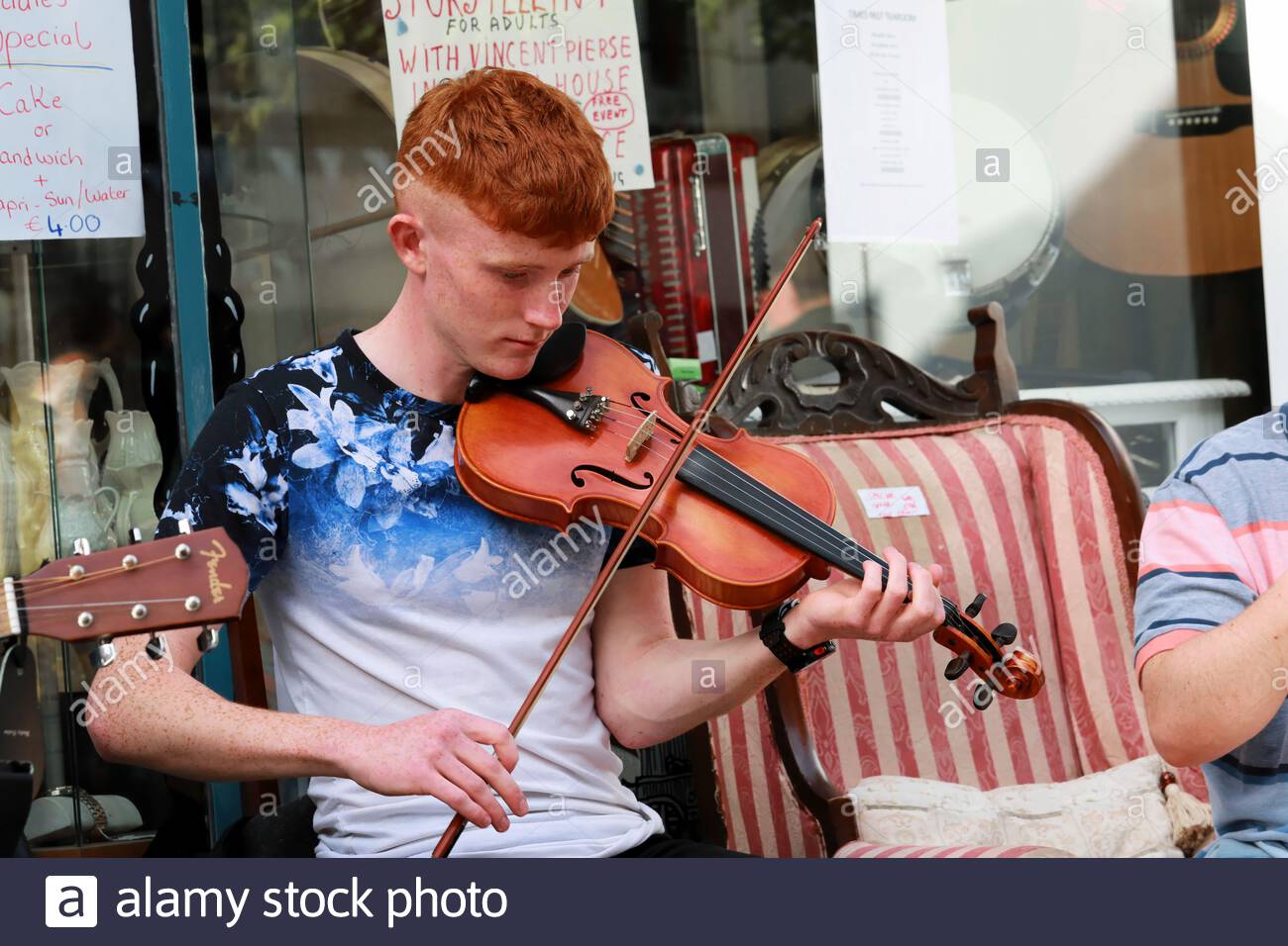 An Irish musician playing the fiddle on a  street in Drogheda during the Fleadh Cheoil, an annual traditional music festival. Stock Photo