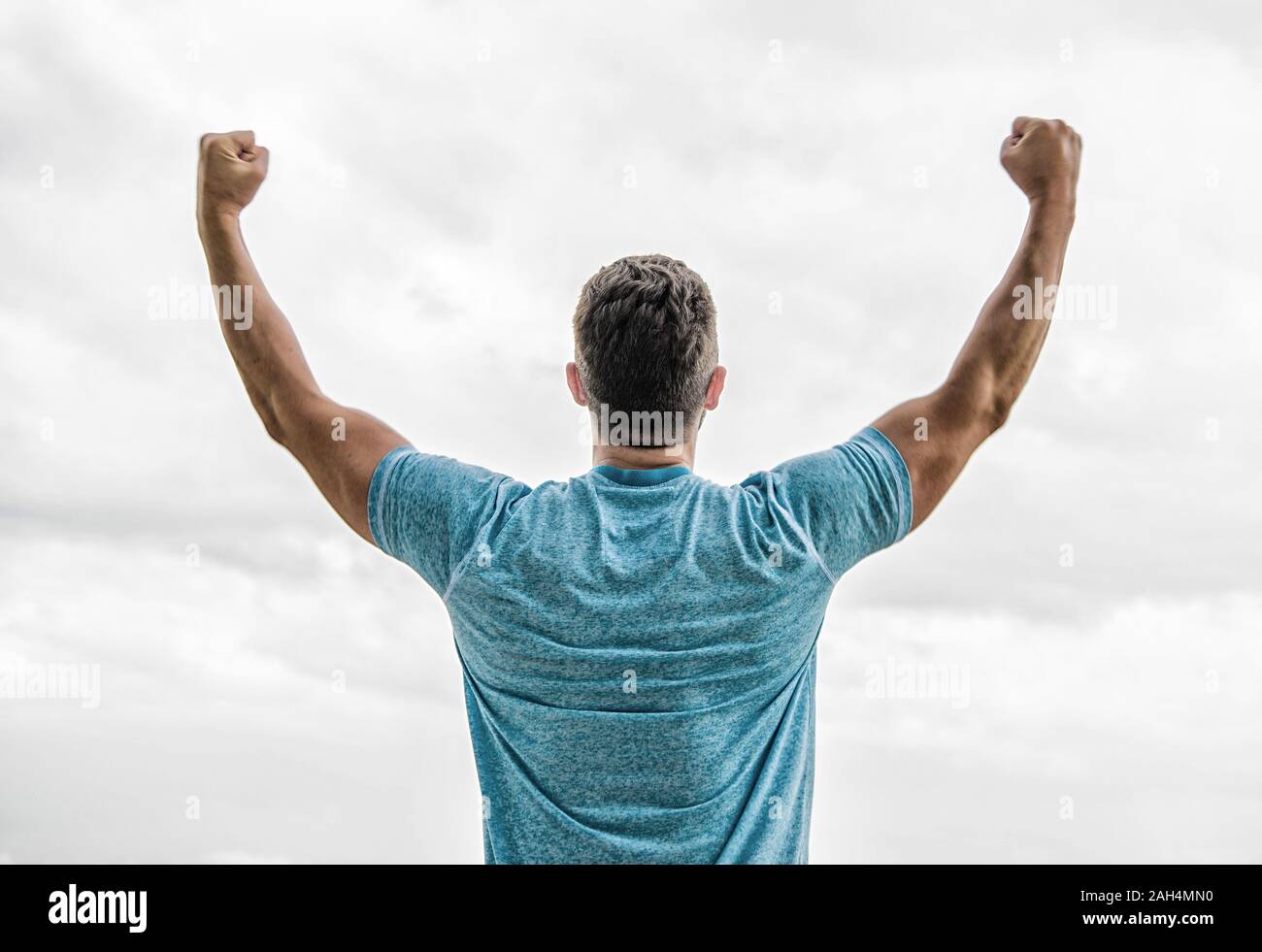 Victory and success. Champion winner. Future opportunity. Leadership and competition. Future concept. Looking forward in future. Strong muscular body feeling powerful rear view. Successful athlete. Stock Photo