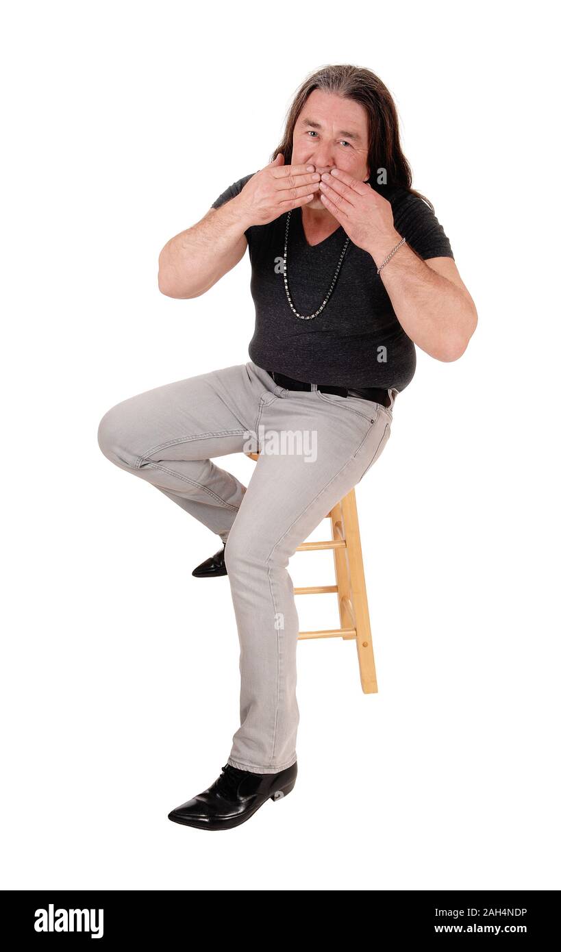 A image of a middle age indigenous man sitting on a chair and blowing a kiss, isolated for white background Stock Photo