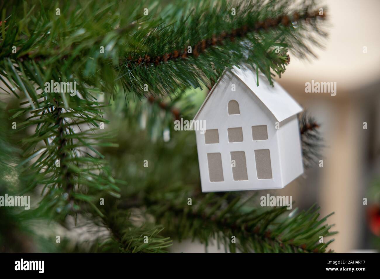 Decorated Christmas tree with house toy on blurred, sparkling and fairy background Stock Photo