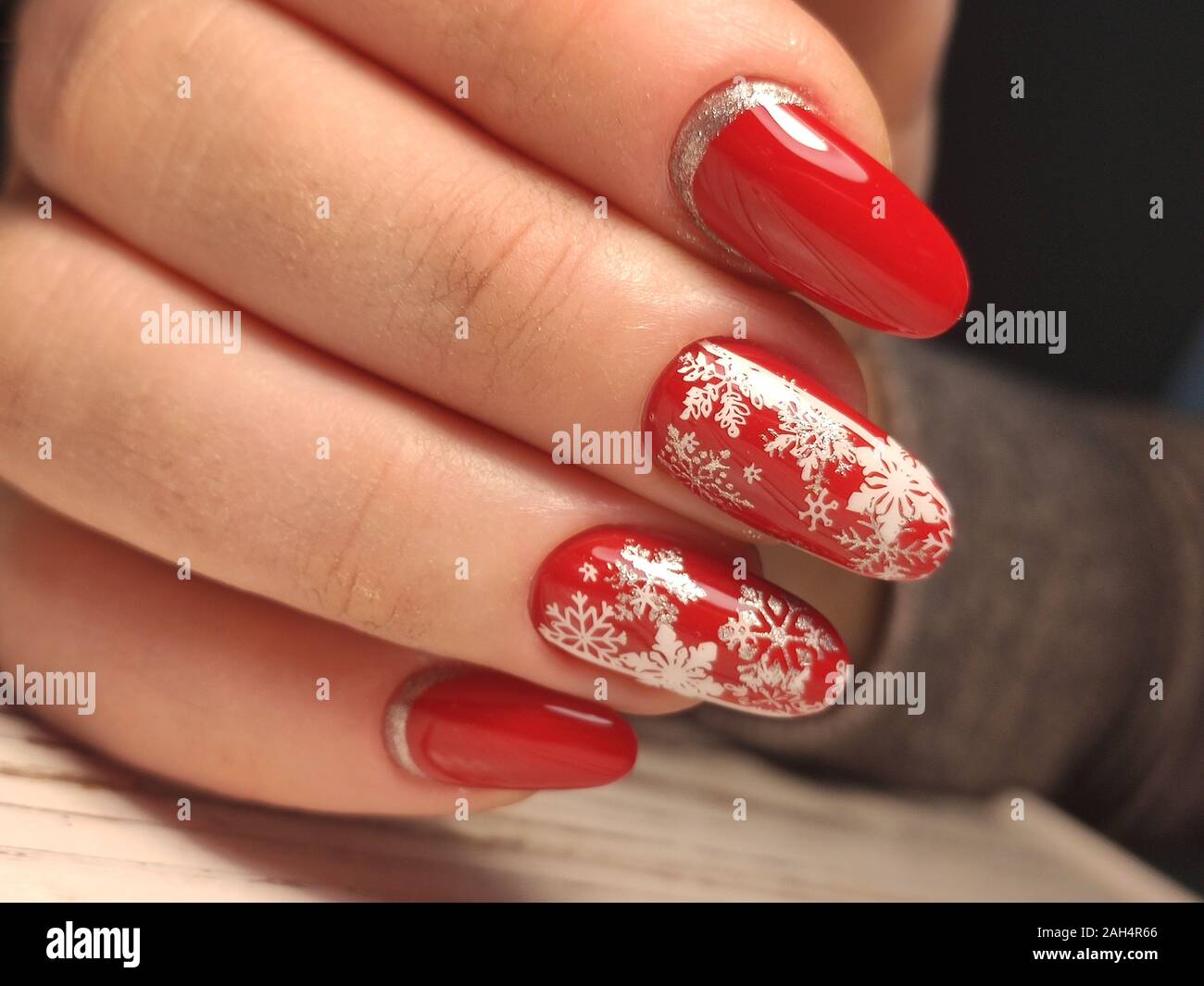 red Christmas manicure with deer and snowflakes and Norwegian pattern with  Christmas ball on the tree Stock Photo - Alamy
