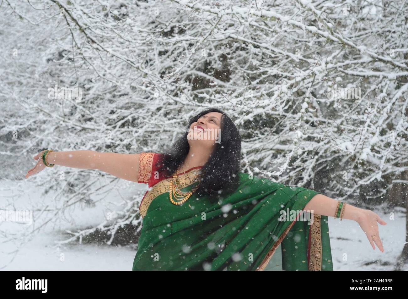 Traditionally dressed confident Indian Woman enjoying snowfall Stock Photo