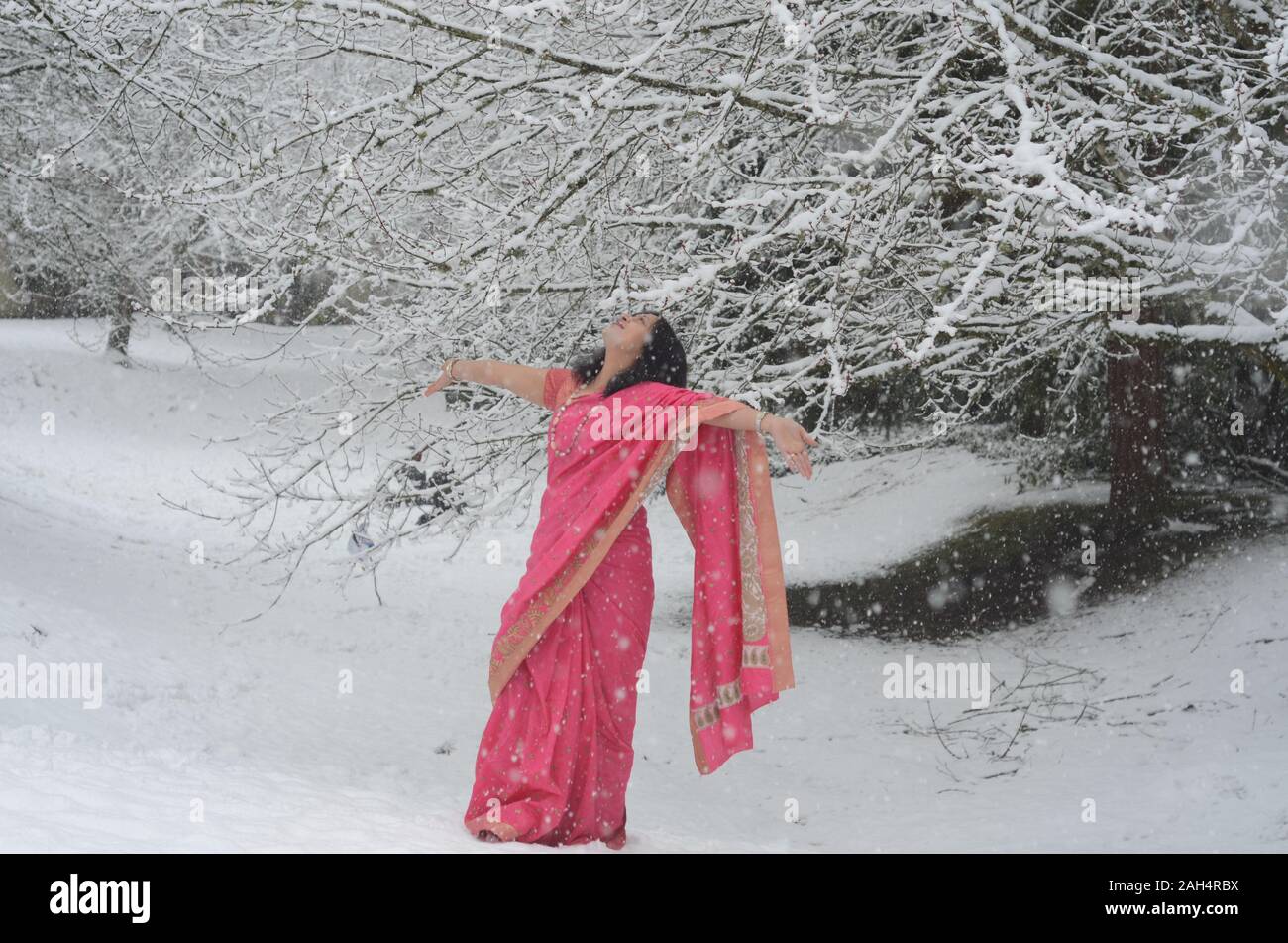 Traditionally dressed confident Indian Woman enjoying snowfall Stock Photo