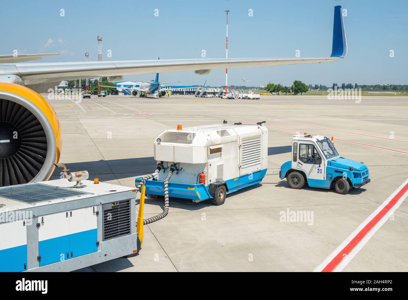 Big modern commercial plane parked on airport runway and connected to ground supply power unit. Aircraft maintenance service and check-up before Stock Photo