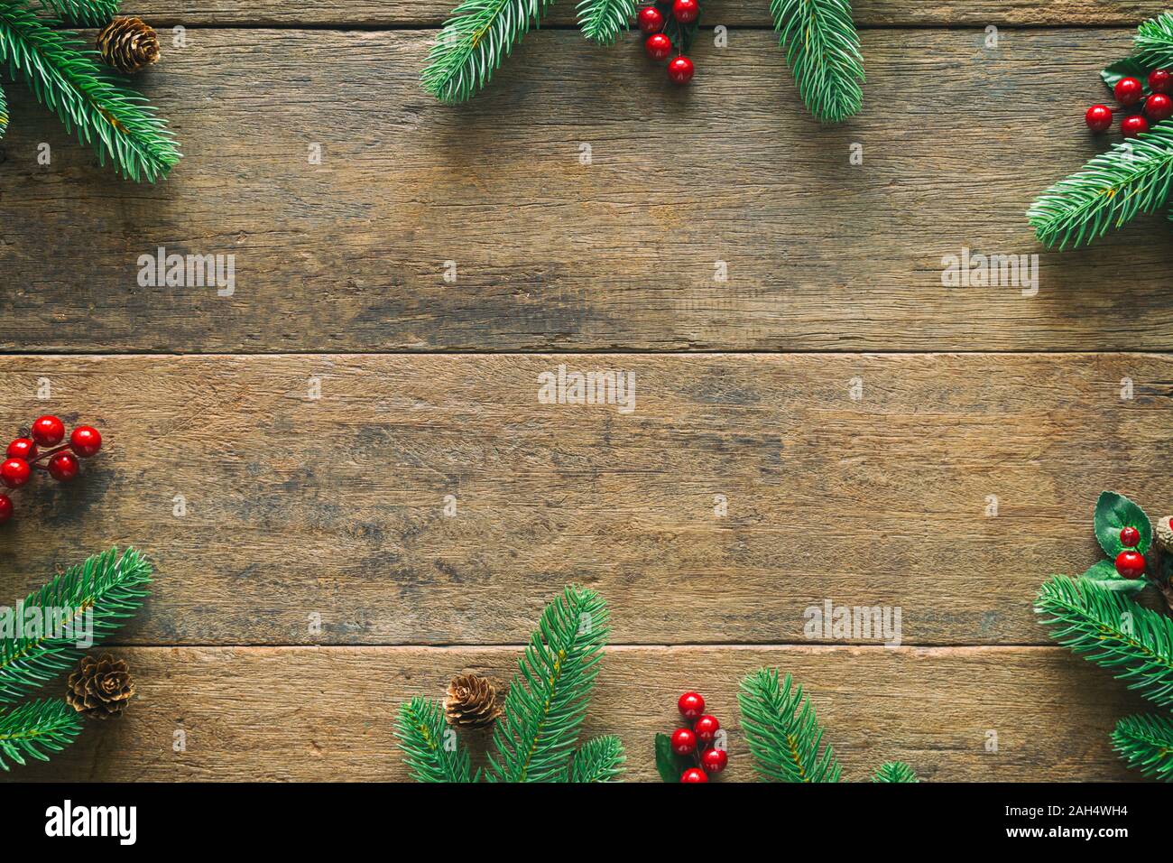 Holiday Christmas card background with festive decoration ball, stars, snowflakes, gift box, pine cones on a wood background from Flat lay, top view. Stock Photo