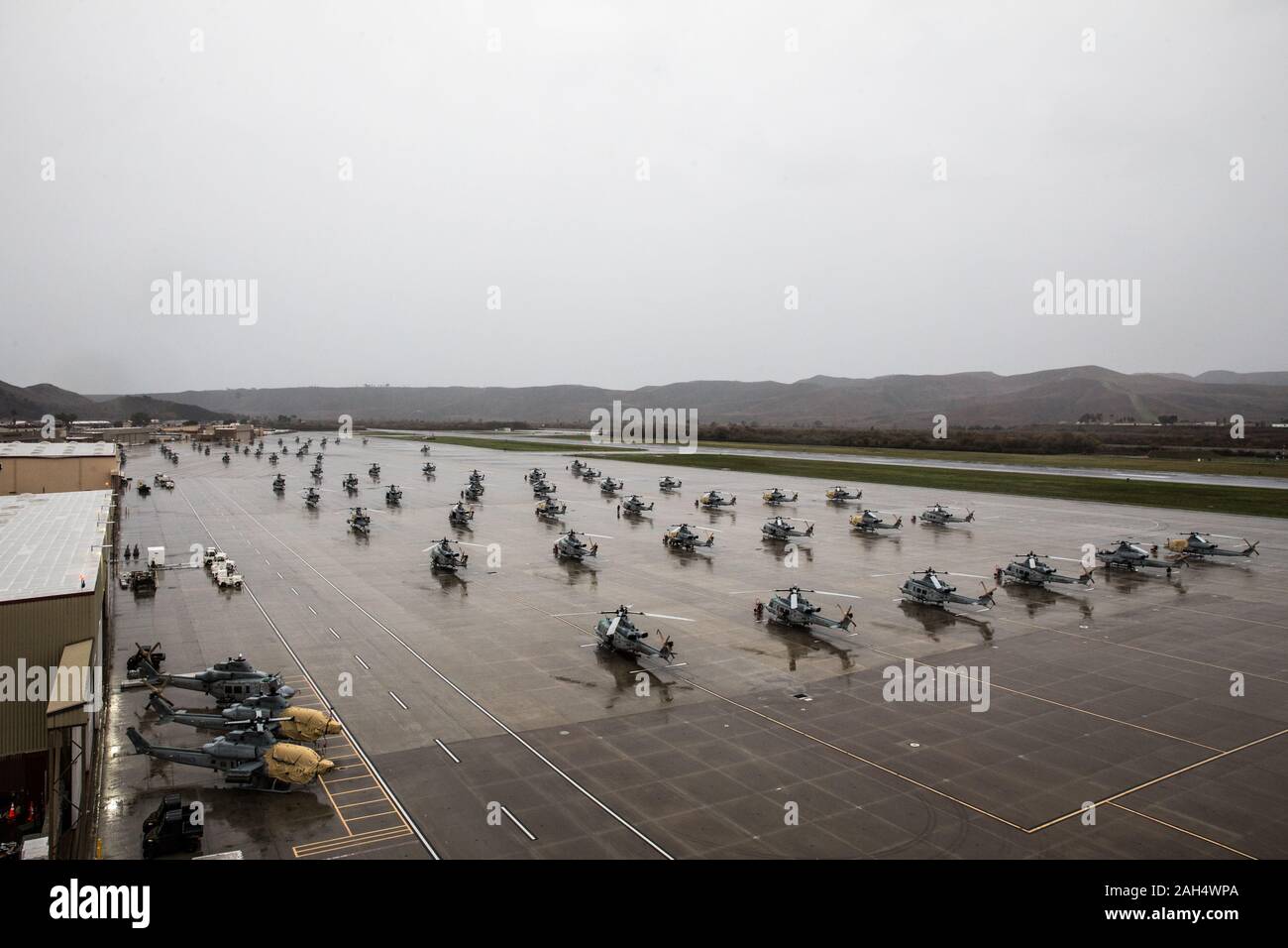 U.S. Marine aircraft sit in the rain on Marine Corps Air Station Camp Pendleton, California, Dec. 23, 2019. MCAS Camp Pendleton operates and maintains a secure airfield in order to support I Marine Expeditionary Force, Marine Corps Base Camp Pendleton tenant commands and visiting units to maintain and enhance their mission capabilities and combat readiness. (U.S. Marine Corps photo by Lance Cpl. Alison Dostie) Stock Photo