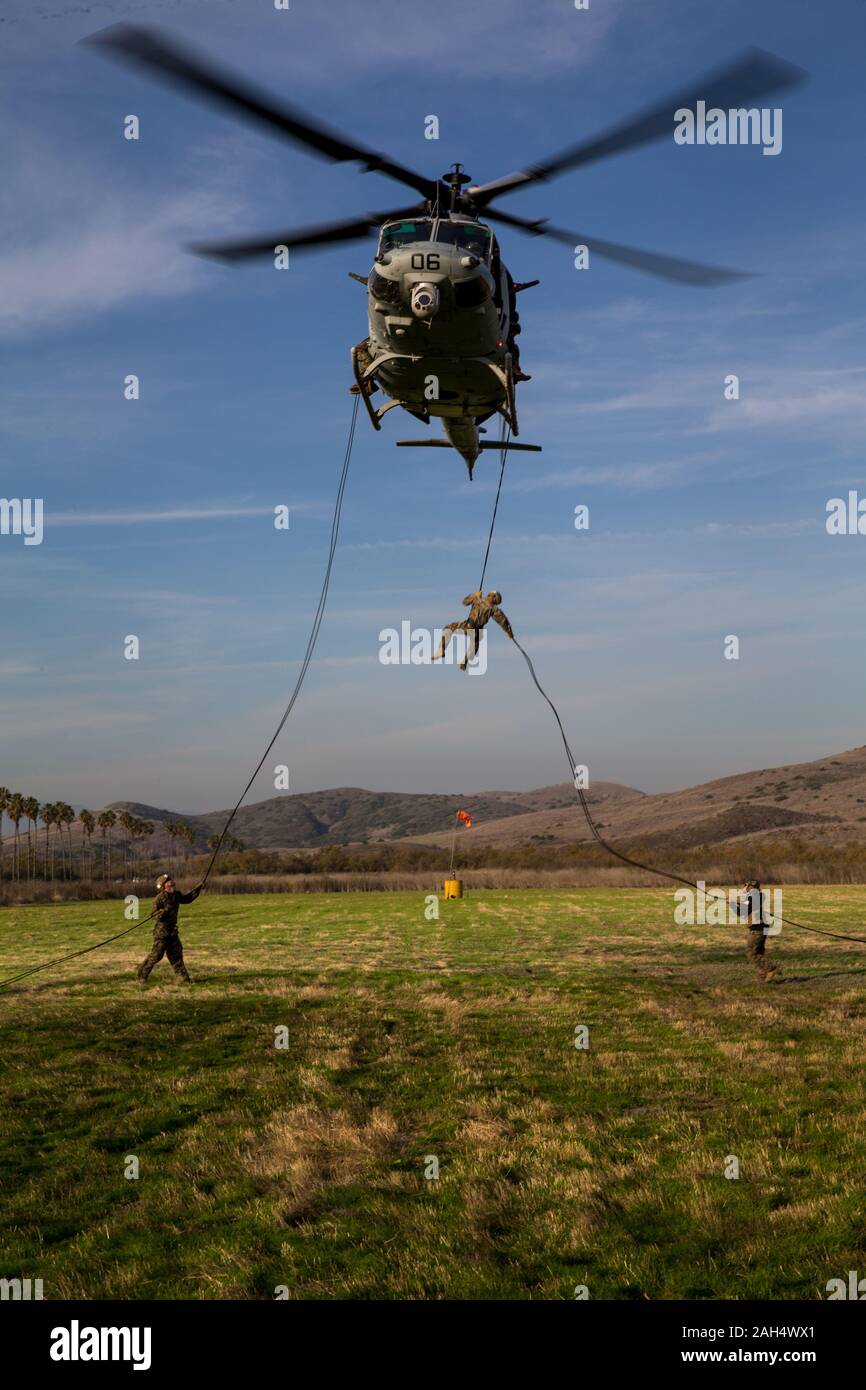 U.S. Marines practice rappelling out of a UH-1Y Venom with Marine Light Attack Squadron 469 during a helicopter rope suspension technician (HRST) masters course at Marine Corps Base Camp Pendleton, California, Dec. 11, 2019. The course provided the students the ability to conduct HRST techniques safely on their own, including special purpose insertion/extraction (SPIE) rigging, fast roping, and rappelling from helicopters, enabling their units to be able to insert and extract anywhere, even when a landing zone is unavailable. (U.S. Marine Corps photo by Lance Cpl. Brendan Mullin) Stock Photo