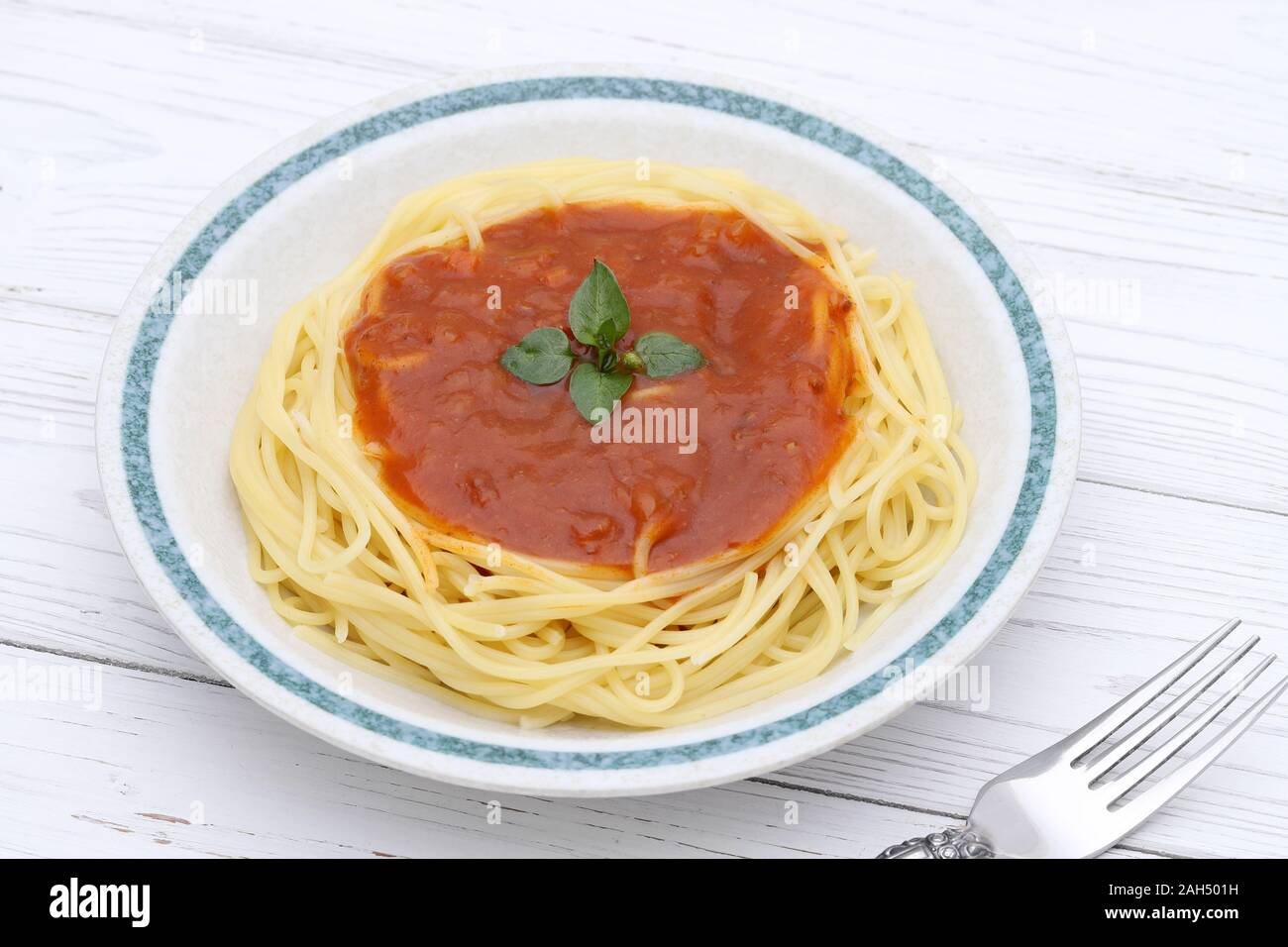 Pasta spaghetti with tomato sauce and basil on table Stock Photo