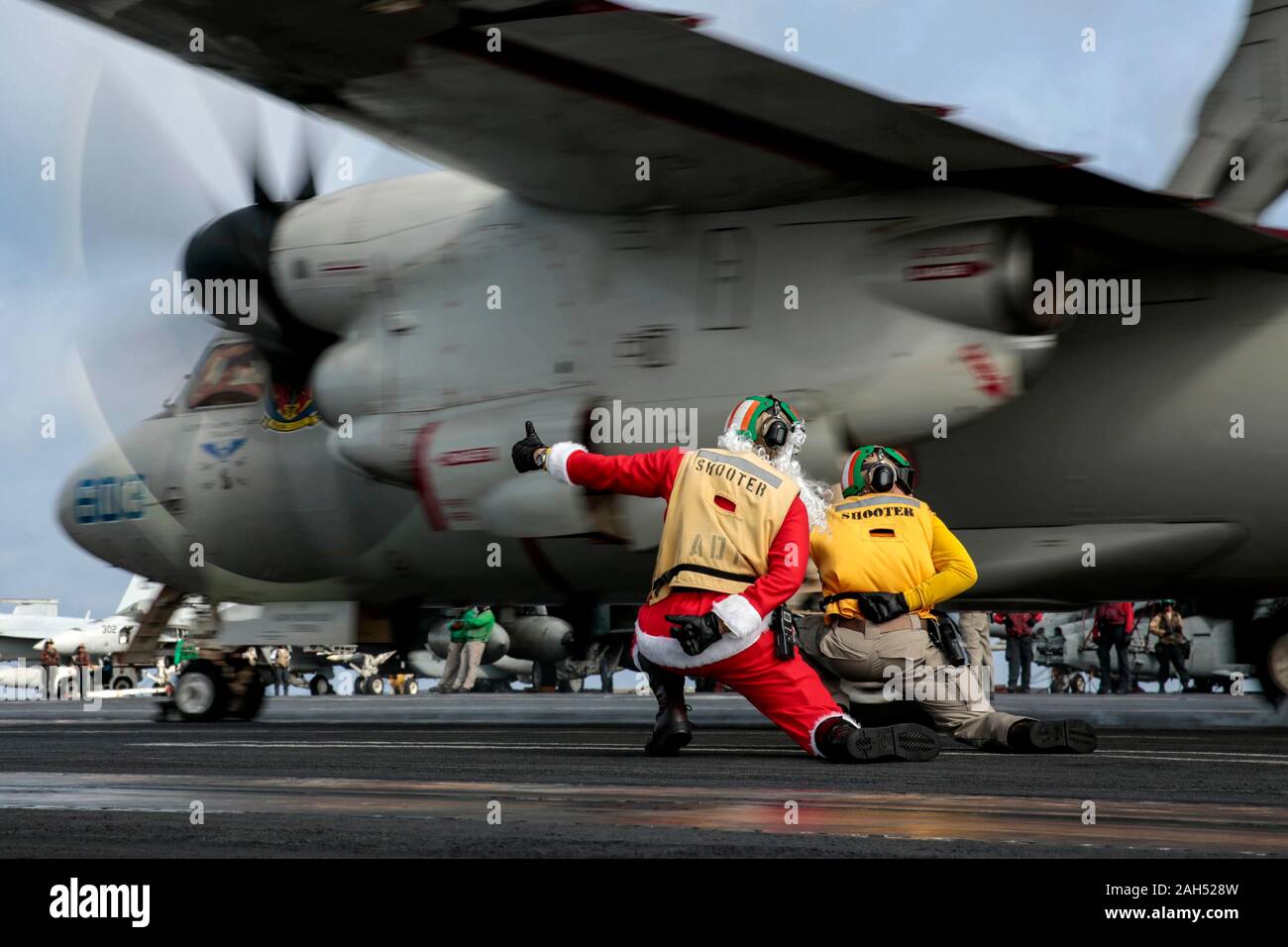 USS Abraham Lincoln, United States. 24 December, 2019. A U.S. Navy sailor dressed as Santa Claus directs an E-2D Hawkeye aircraft on the flight deck of the Nimitz-class aircraft carrier USS Abraham Lincoln during operations on Christmas Eve December 24, 2019 in the South China Sea.  Credit: Michael Singley/U.S. Navy/Alamy Live News Stock Photo