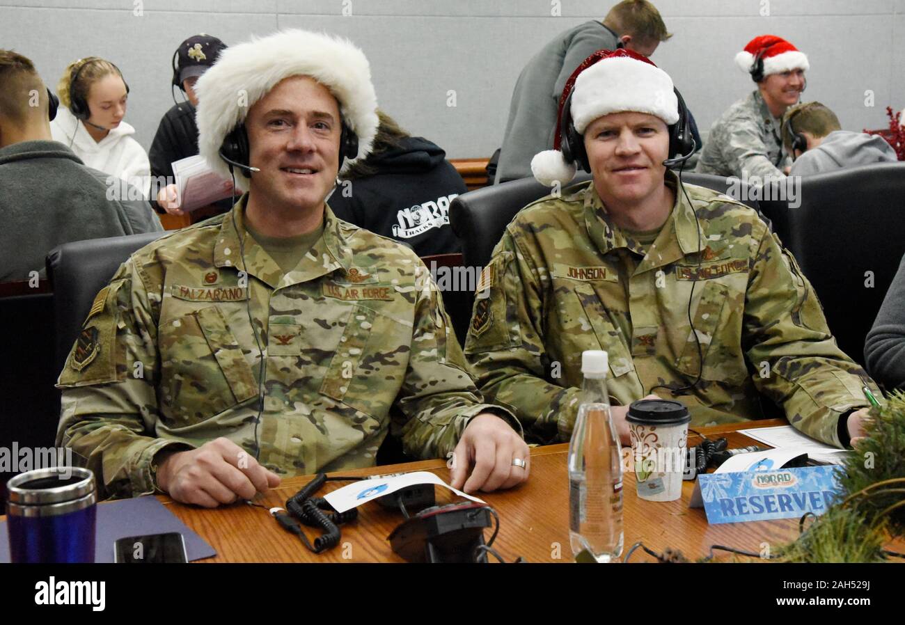 Colorado Springs, United States. 24 December, 2019. U.S. Col. Thomas Falzarano, 21st Space Wing commander, and Col. Sam Johnson, 21st SW vice commander, volunteer as Santa Trackers at the 2019 NORAD Tracks Santa Operation Center at Peterson Air Force Base December 24, 2019 in Colorado Springs, Colorado. The North American Aerospace Defense Command volunteers to answer 137,000 phone calls and 4,900 emails from children around the world asking where Santa is and when will he arrive at their house. Credit: Alexandra M. Longfellow/Planetpix/Alamy Live News Stock Photo