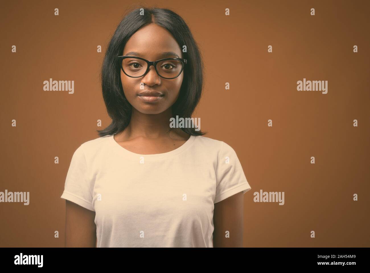 Studio shot of young beautiful African Zulu woman wearing white shirt ...