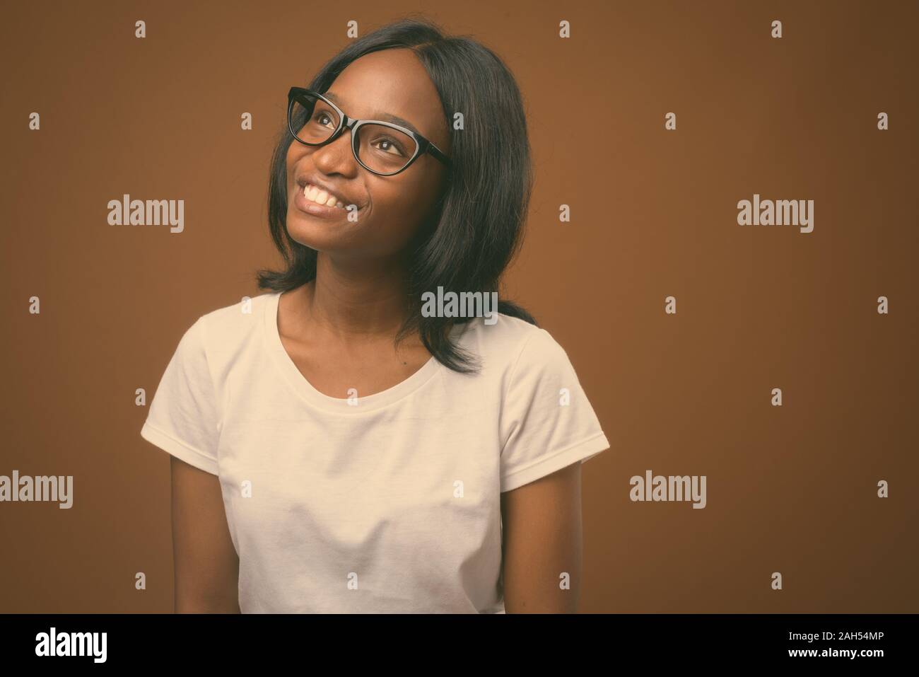 Studio shot of young beautiful African Zulu woman wearing white shirt ...