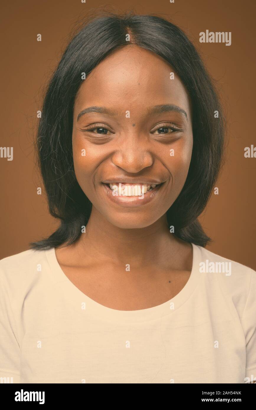 Studio shot of young beautiful African Zulu woman wearing white shirt ...