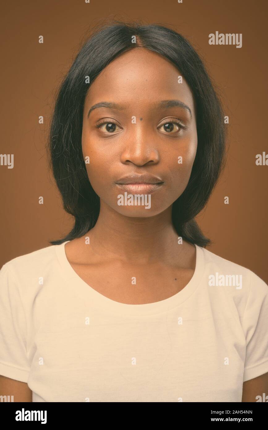 Studio shot of young beautiful African Zulu woman wearing white shirt ...