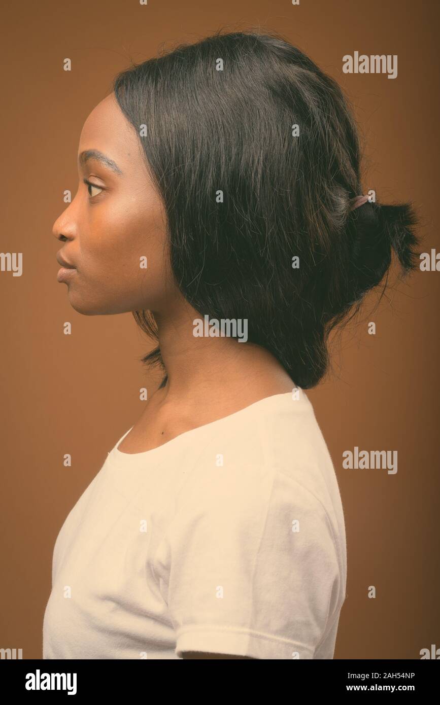 Studio shot of young beautiful African Zulu woman wearing white shirt ...