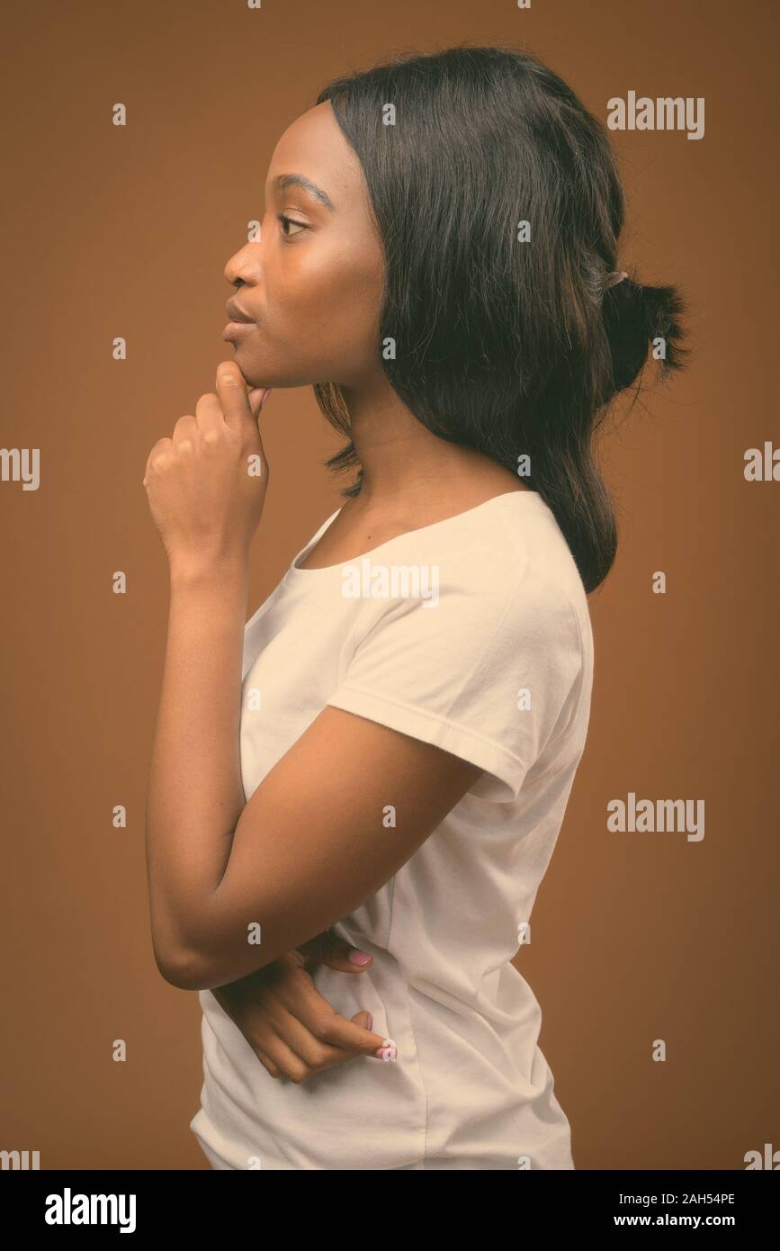 Studio shot of young beautiful African Zulu woman wearing white shirt ...